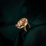 Elegant gold ring on dark fabric